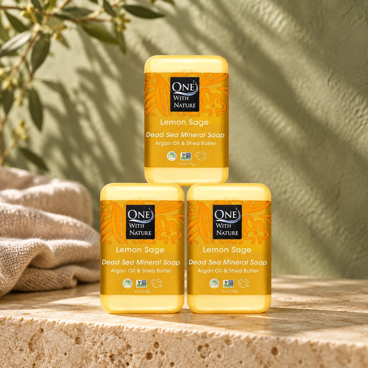 Three Lemon Sage soap bars on warm stone